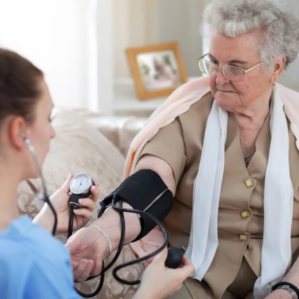 Home care Medical professional checking blood pressure of an elderly patient