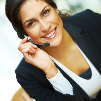 Female receptionist using headset and smiling