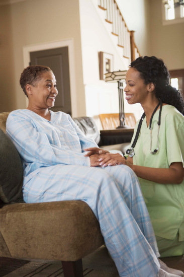 Nurse smiling with patient at home