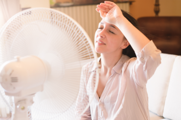 Woman feeling hot and sweating at home