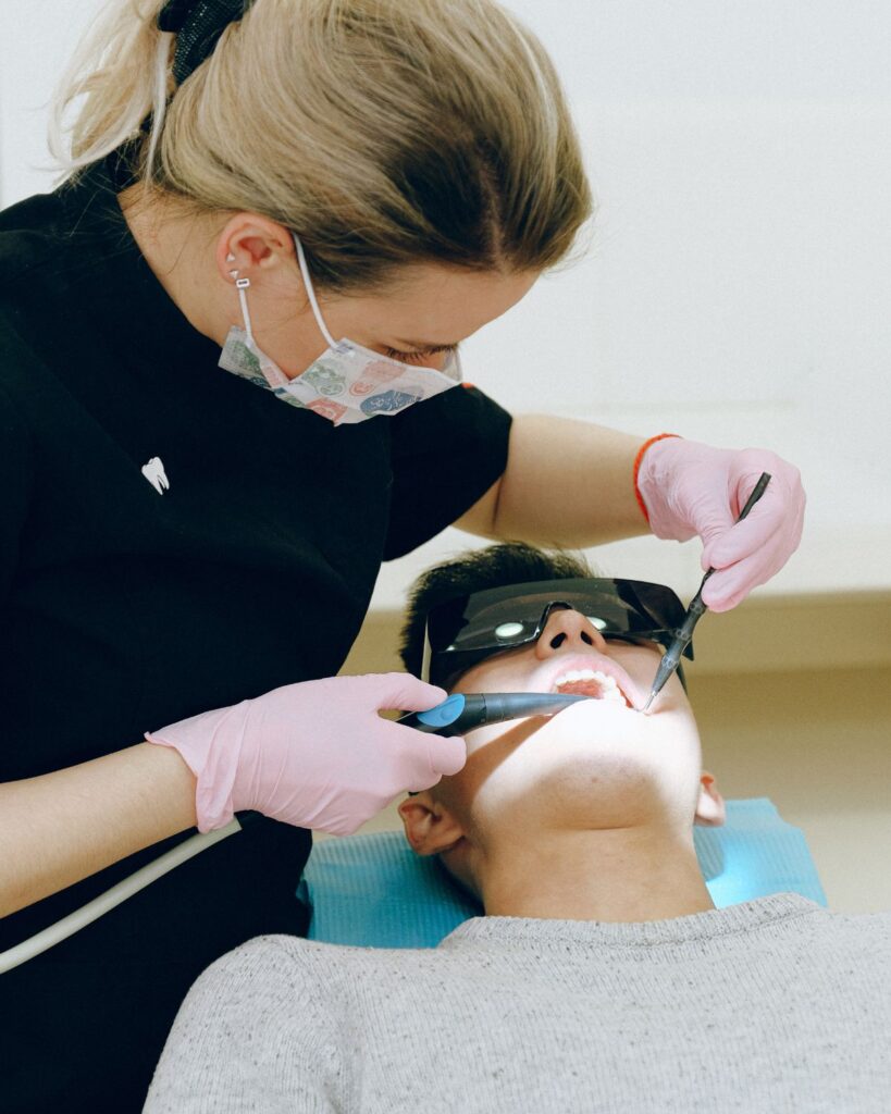 A female dentist is checking a dental patient