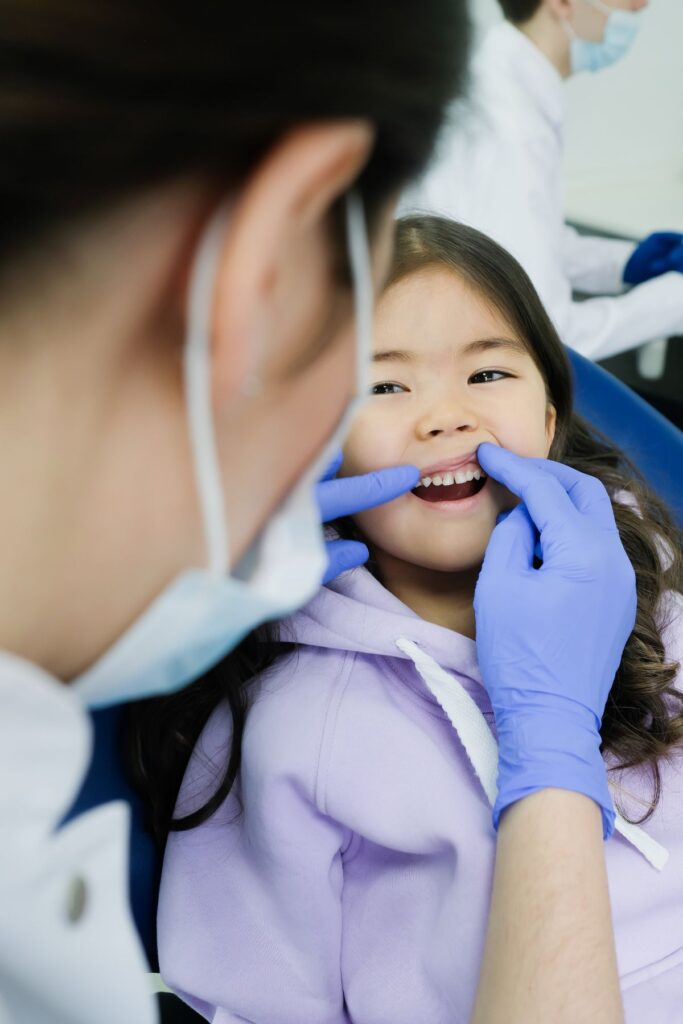 A dentist is checking the teeth of a child