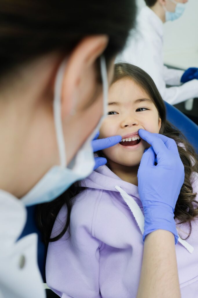 A dentist is checking the teeth of a child